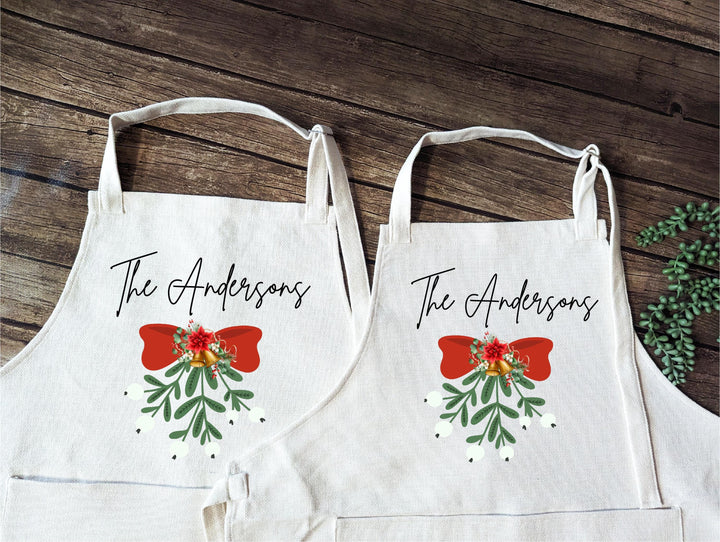 Personalized Christmas Apron Set – Custom Family Name Aprons with Holiday Bow &amp; Mistletoe Design, Couple Baking Gift, Festive Kitchen Set
